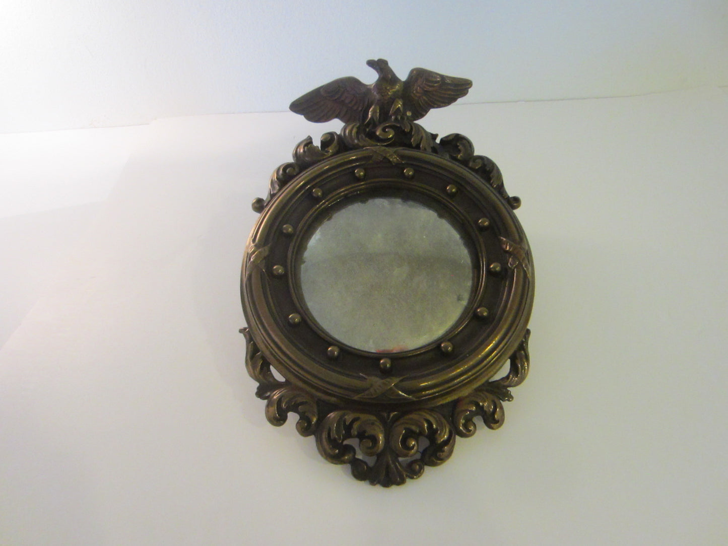 A Pair of Colonial Antiqued Eagle Crest Mid Century Convex Mirrors