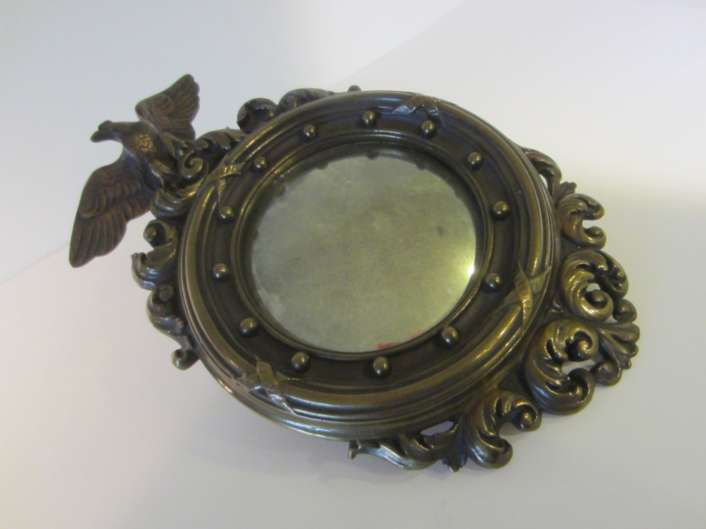 A Pair of Colonial Antiqued Eagle Crest Mid Century Convex Mirrors