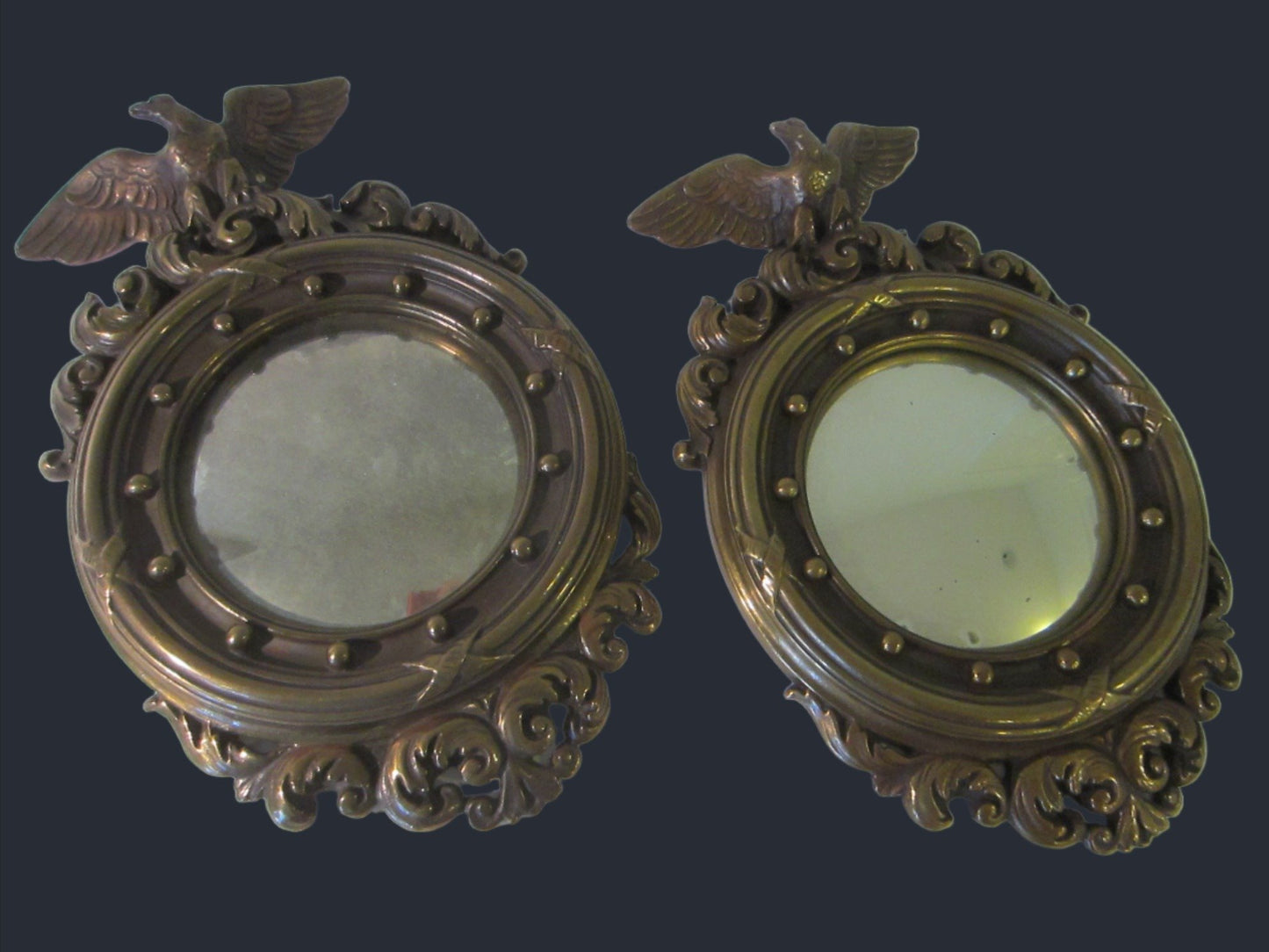 A Pair of Colonial Antiqued Eagle Crest Mid Century Convex Mirrors